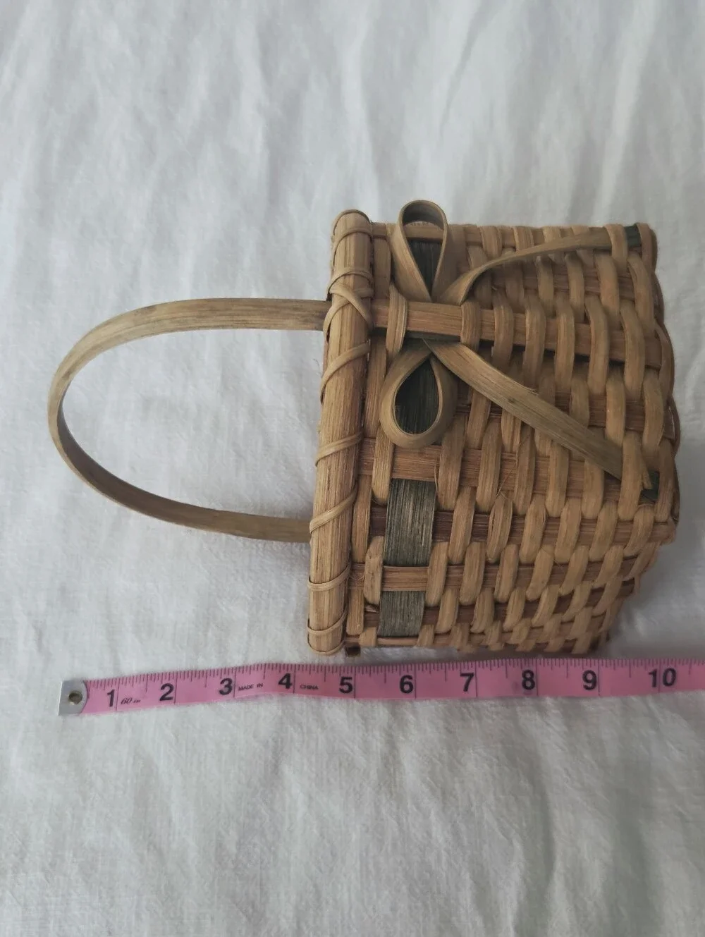 Vintage, Hand-Woven Basket Featuring A Unique Bow Detail And Green Accent